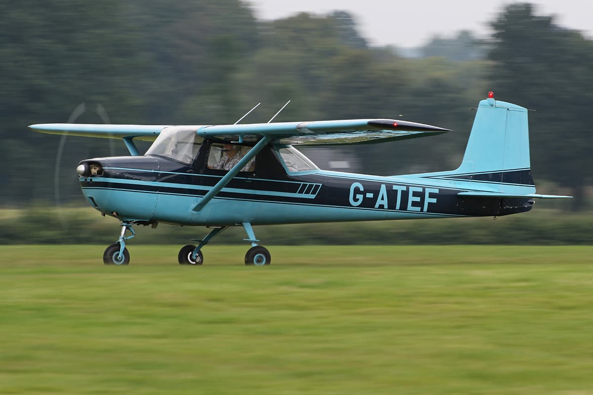 G-ATEF in flight low over the grass airfield, three-quarter front view